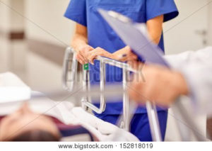 Nurse holding onto hospital bed