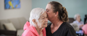 daughter embraces elderly mother