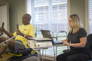 A man works out with a physical therapist